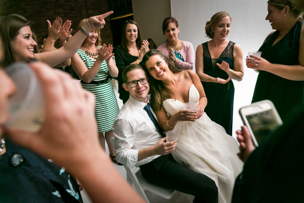 Bride and groom sitting in circle of guests at Bathhouse Studios wedding