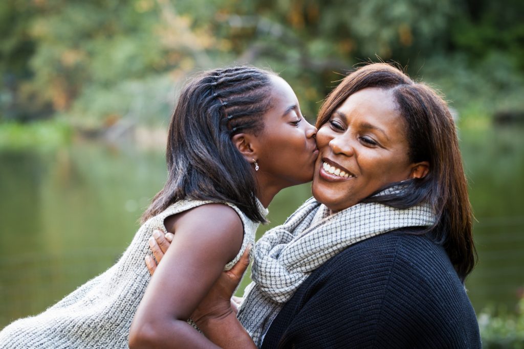 Central Park fall family portrait of daughter kissing mother's cheek