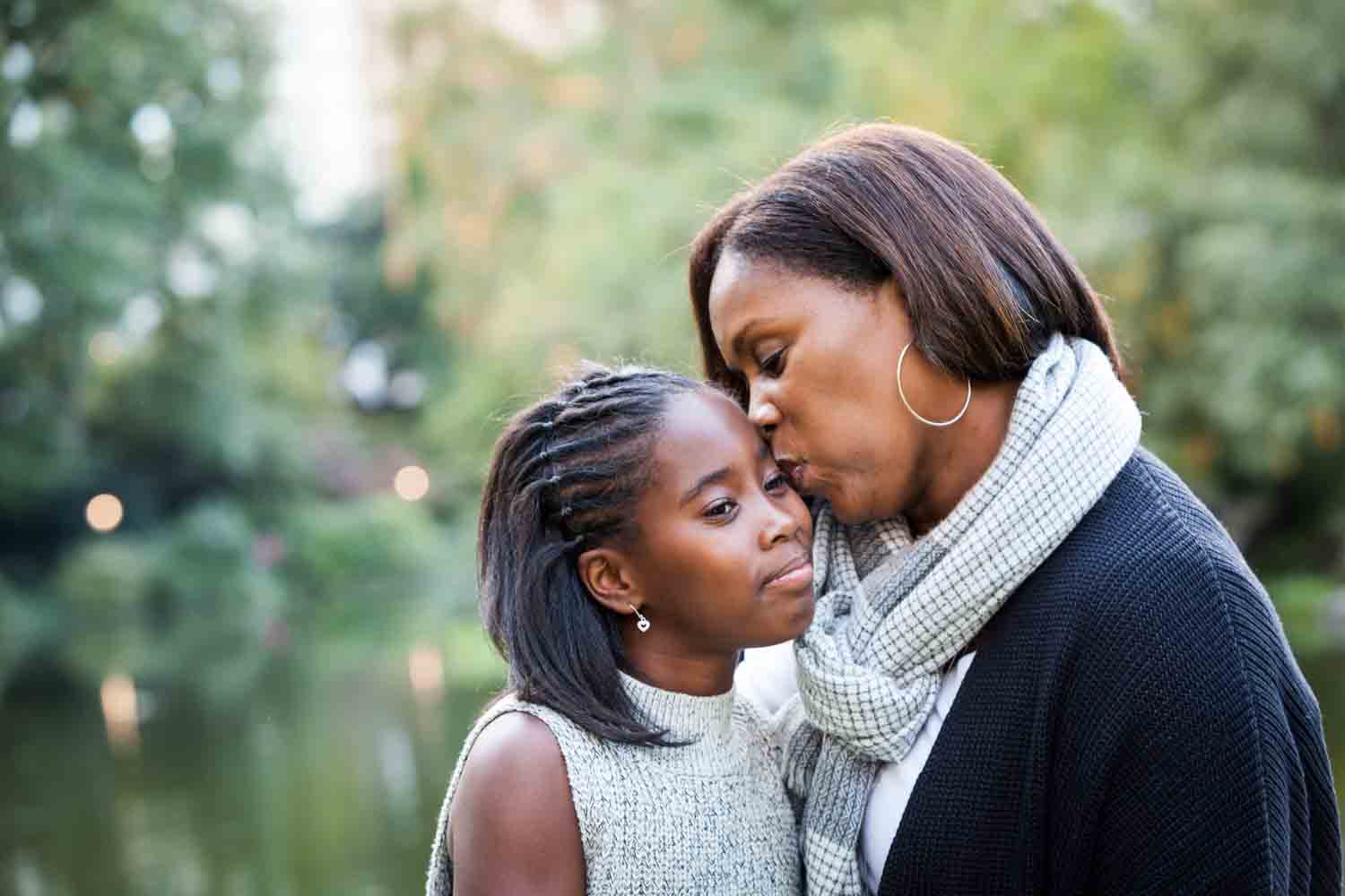 Central Park fall family portrait of mother kissing daughter's face
