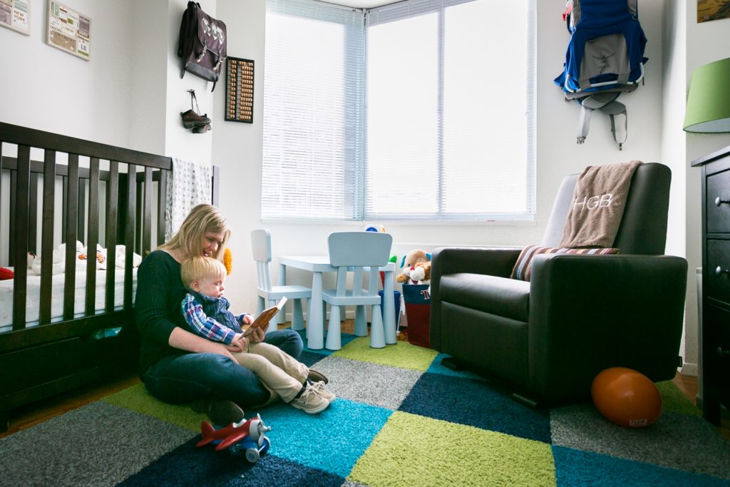 Mother reading to child on the floor of a nursery