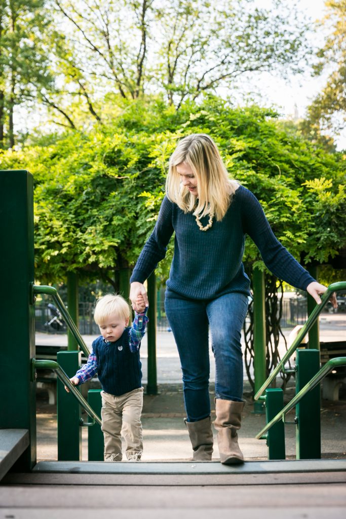 Central Park family photos of mother holding child's hand at playground