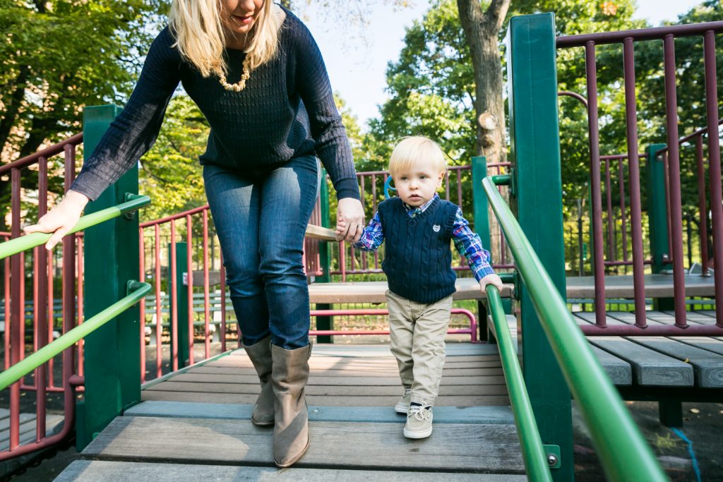 Central Park family photos of mother playing with little boy on playground equipment