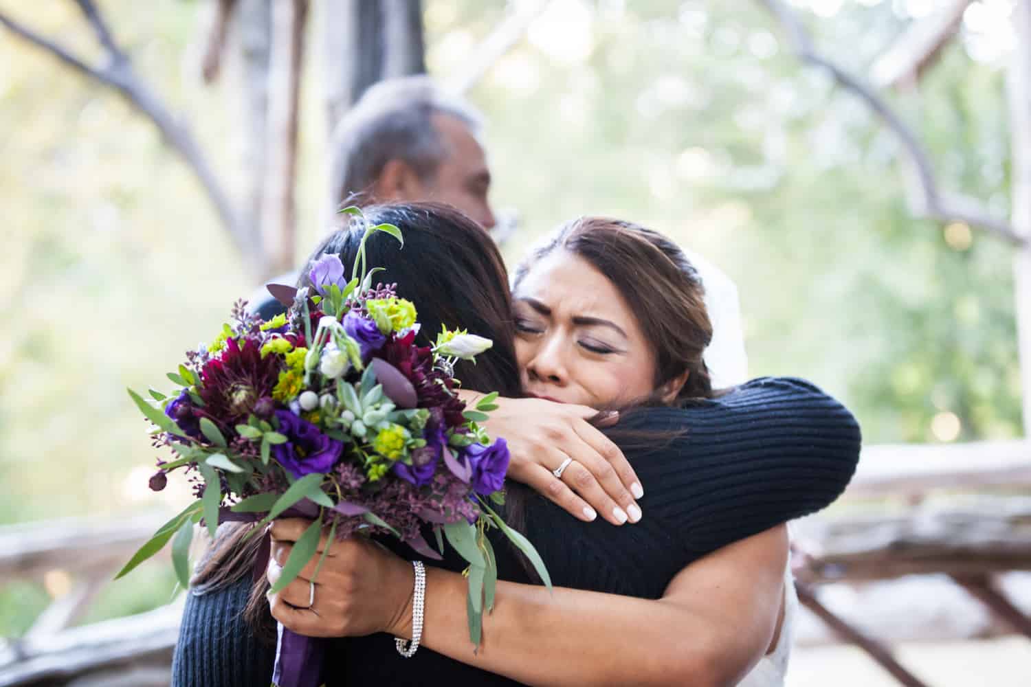 Bride holding bouquet and hugging guest in Cop Cot wedding