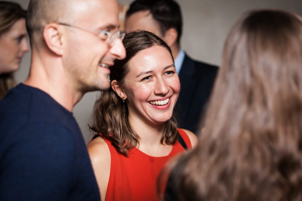 Guest talking to other guests at rehearsal dinner for an article on how to book hotel room blocks