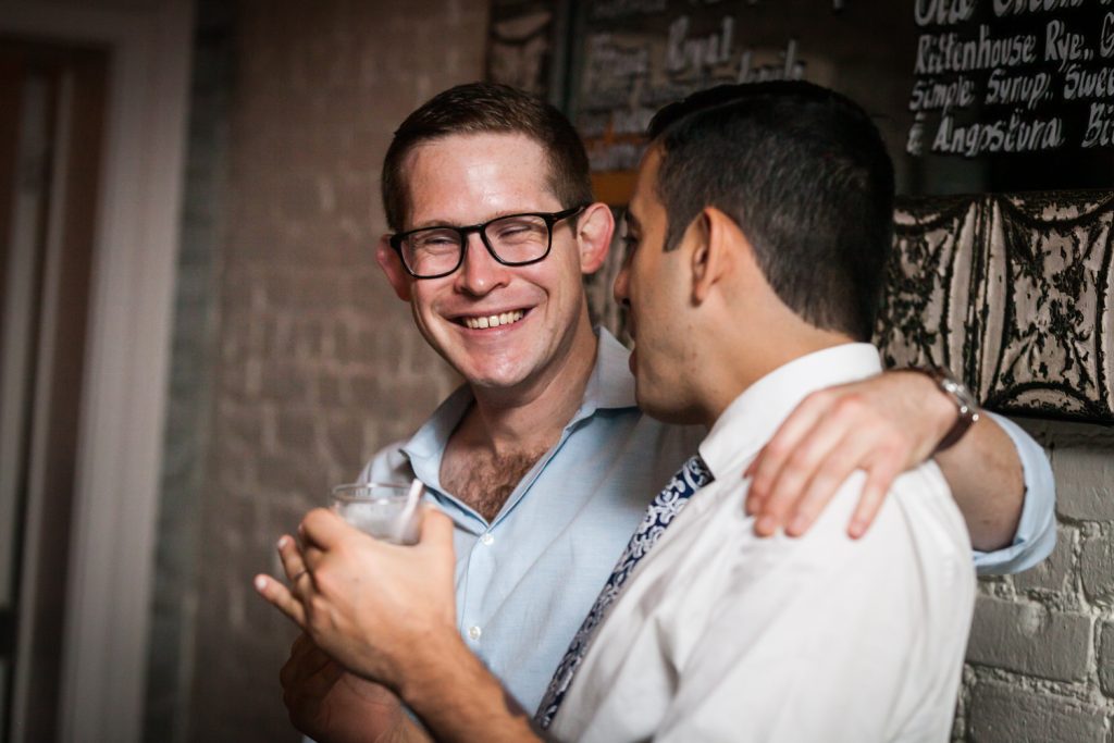 Groom and guest enjoying rehearsal dinner for an article on how to book hotel room blocks