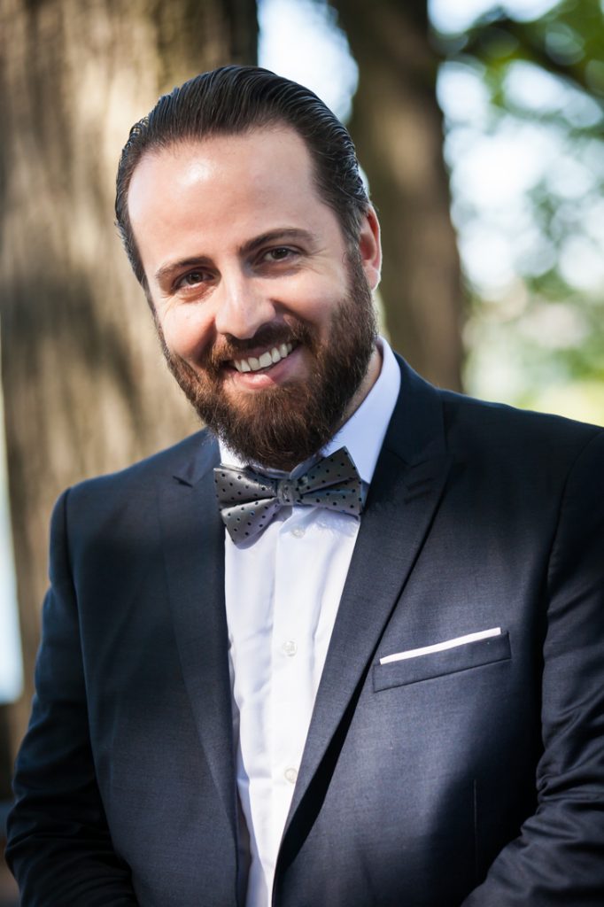 Smiling groom wearing grey bow tie