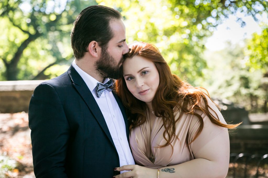 Groom kissing bride on the head for an article on how to plan a destination wedding