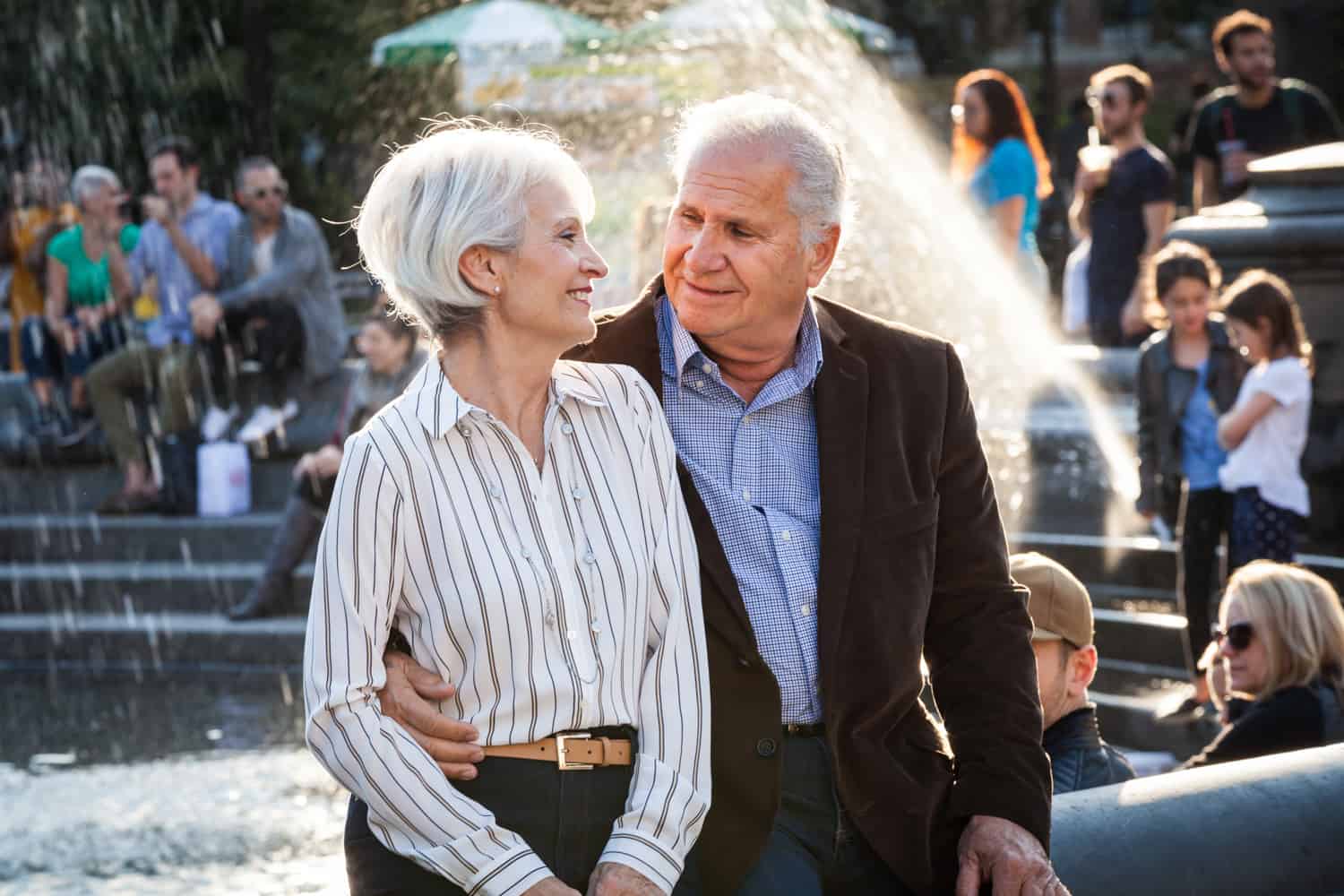 Photojournalistic portraits of older couple sitting on side of fountain in Washington Square Park