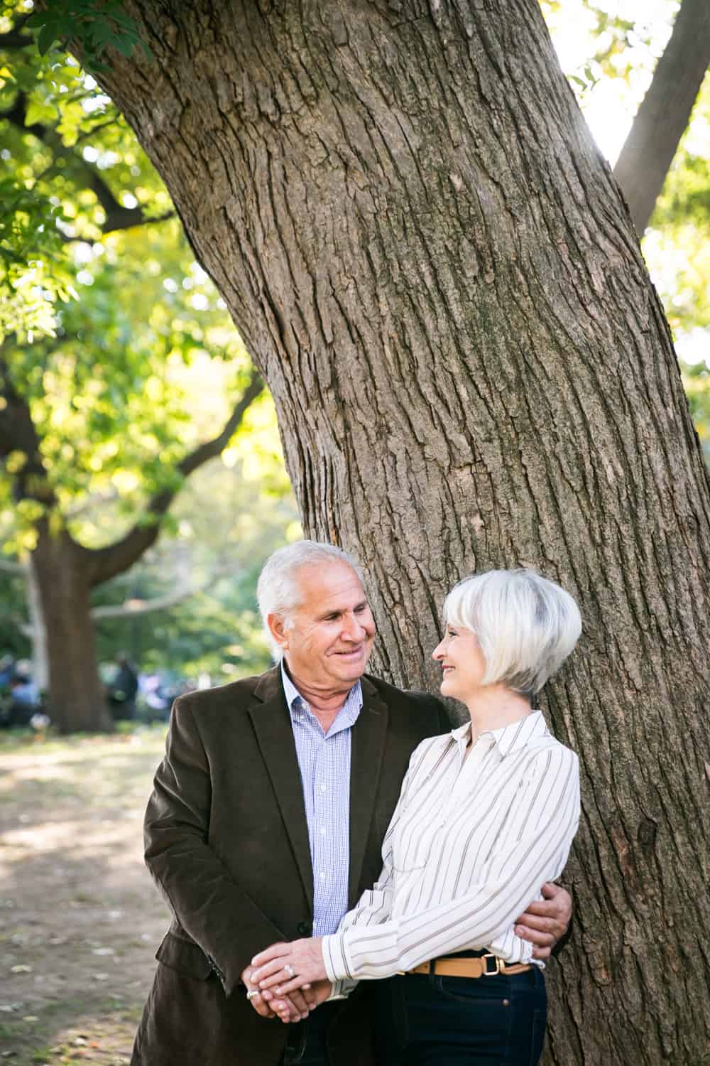 Photojournalistic portraits of older couple standing under tree in Washington Square Park