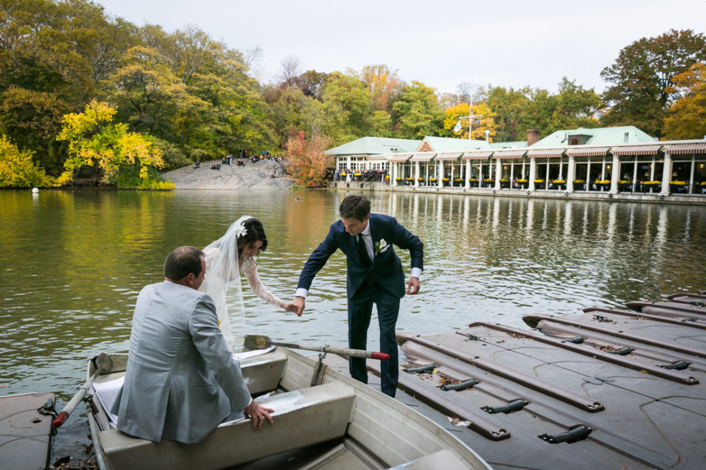 Bride, groom, and groomsman in a Central Park rowboat