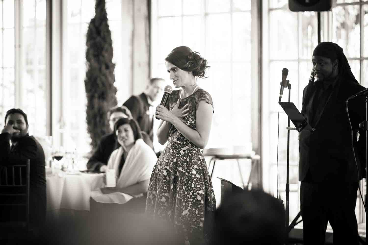Black and white photo of maid of honor making toast
