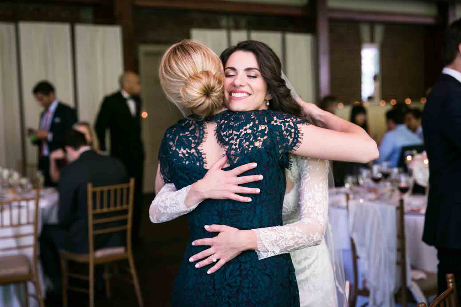 Bride hugging female guest at a Loeb Boathouse wedding in Central Park