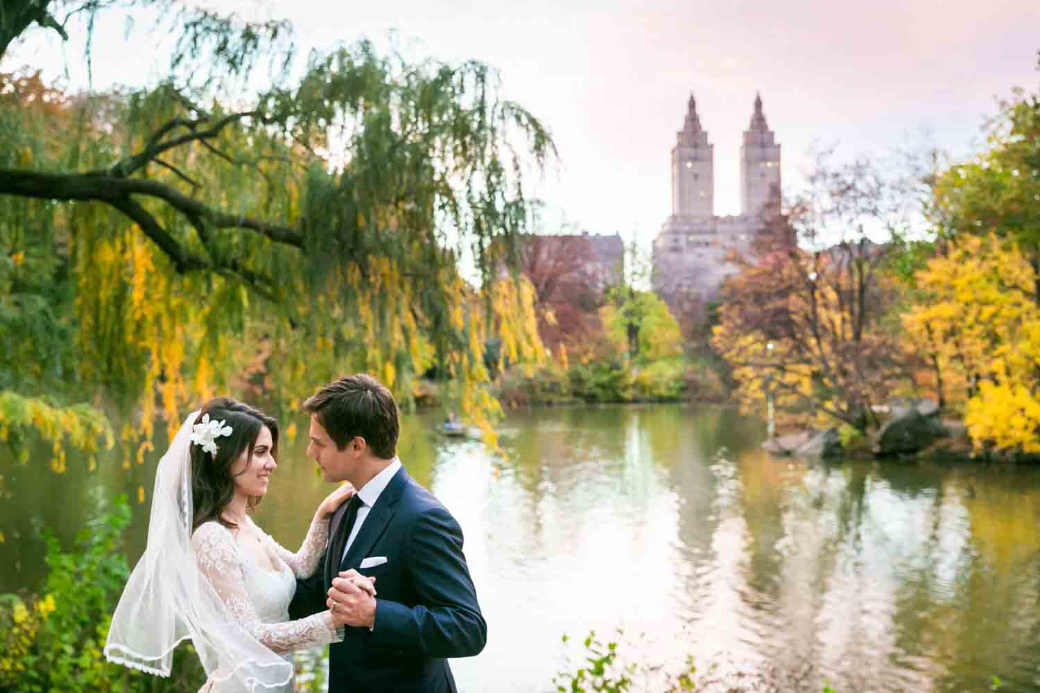 Bride and groom dancing in front of Central Park lake at a Loeb Boathouse wedding