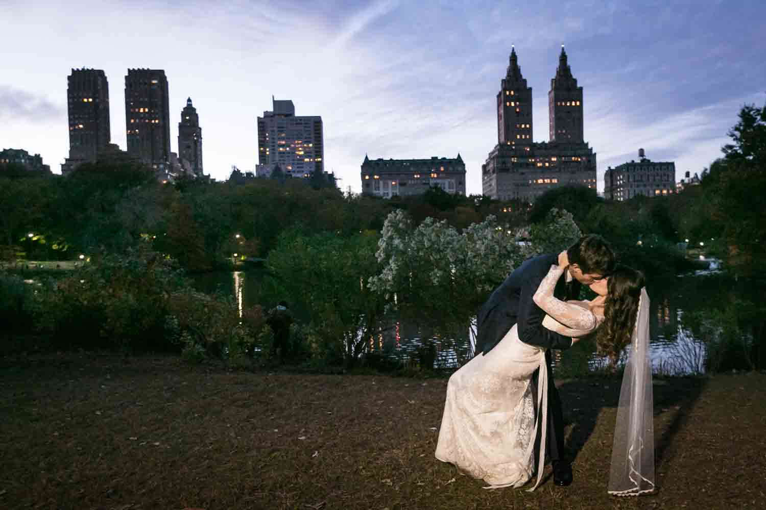 Dramatic kiss in Central Park at night at a Loeb Boathouse wedding