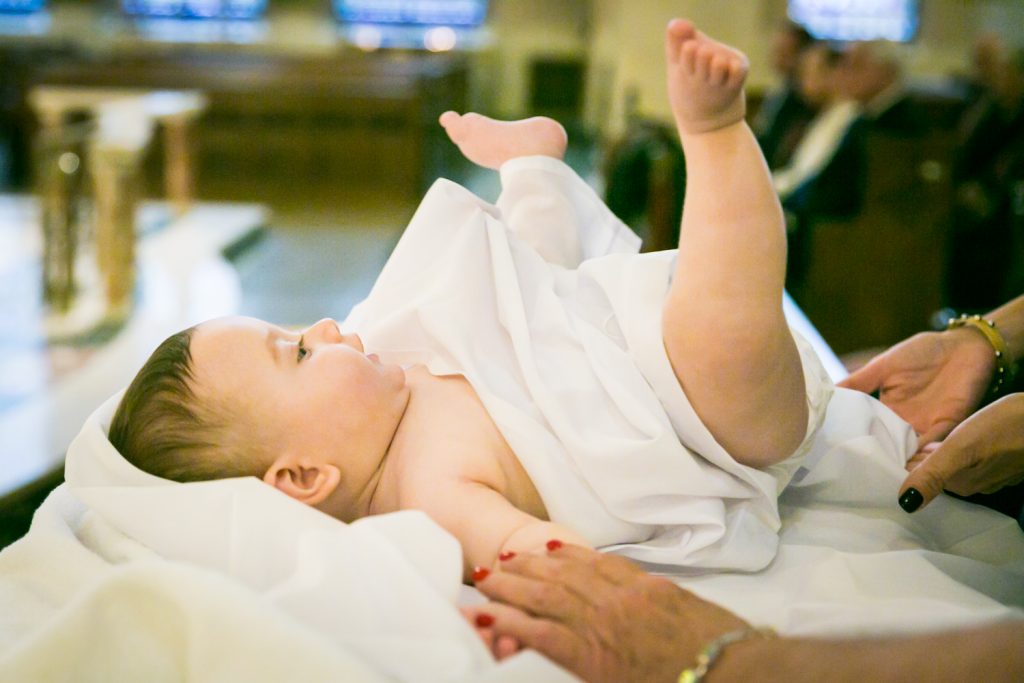 Baby with feet in the air by NYC Greek orthodox baptism photographer, Kelly Williams