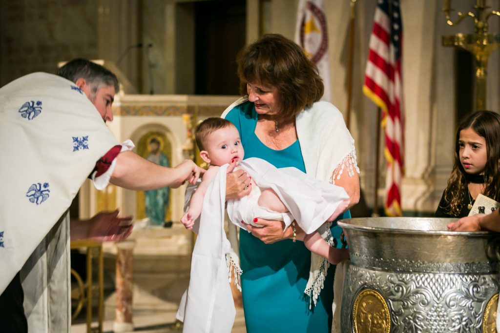 Grandmother holding baby by NYC Greek orthodox baptism photographer, Kelly Williams