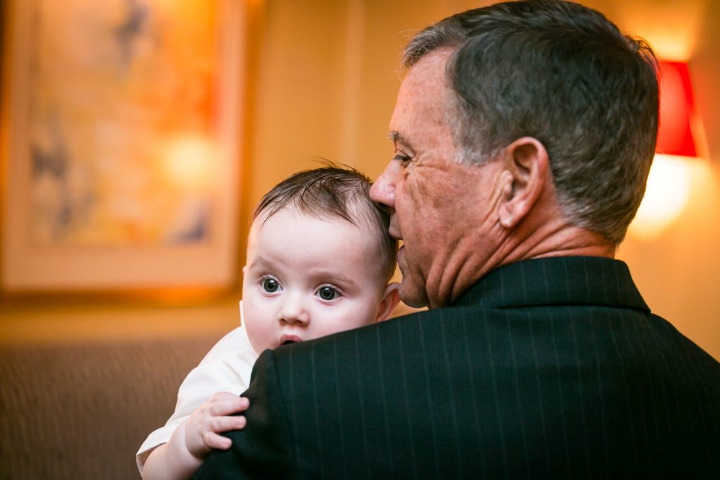 Uncle holding baby by NYC Greek orthodox baptism photographer, Kelly Williams