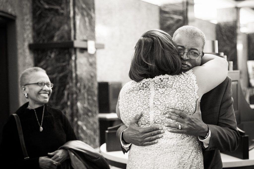 Black and white photo of bride hugging her father