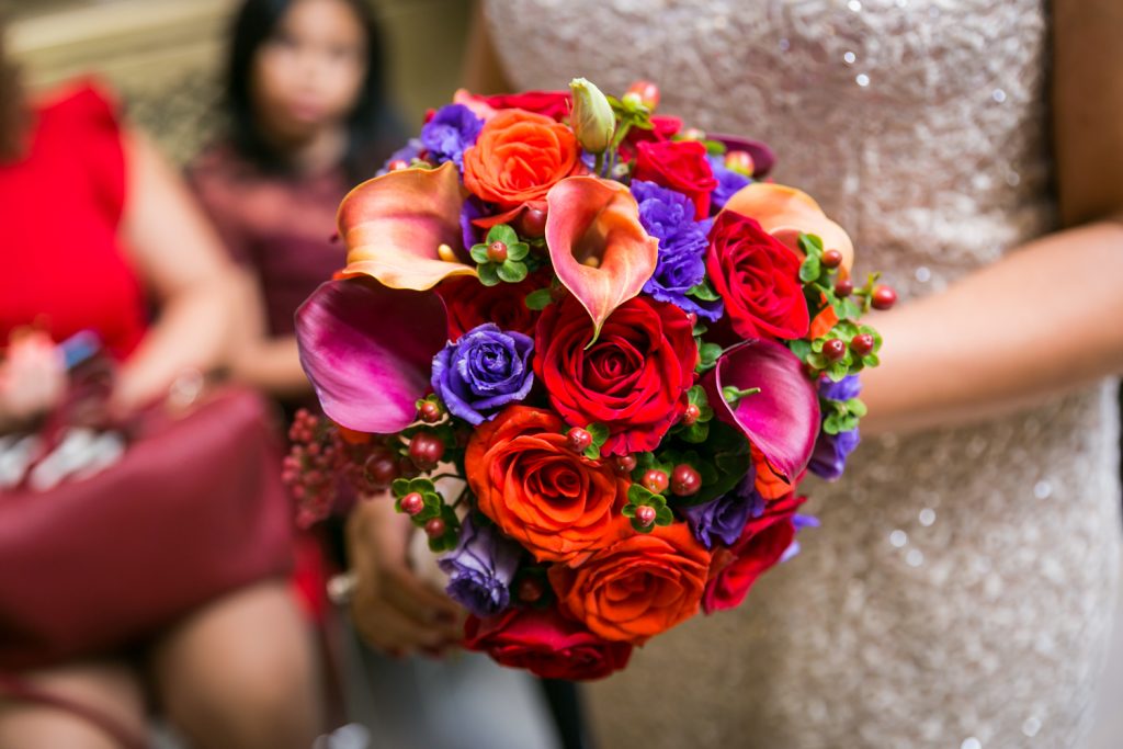 Bride's flower bouquet with red and purple flowers for an article on wedding website tips