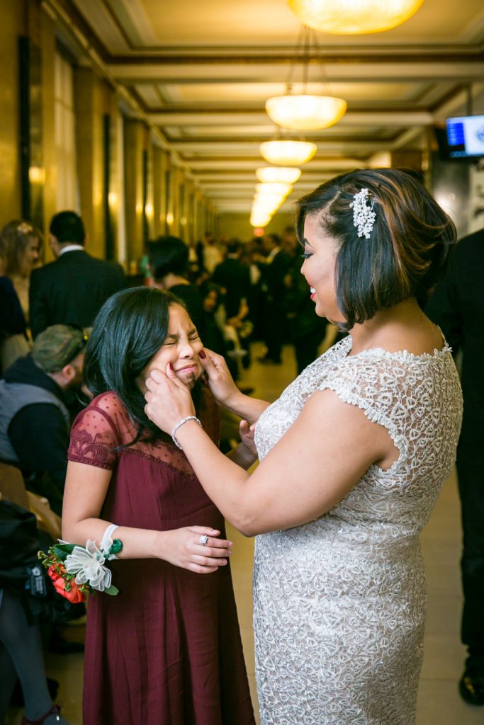 Bride pinching her daughter's cheeks