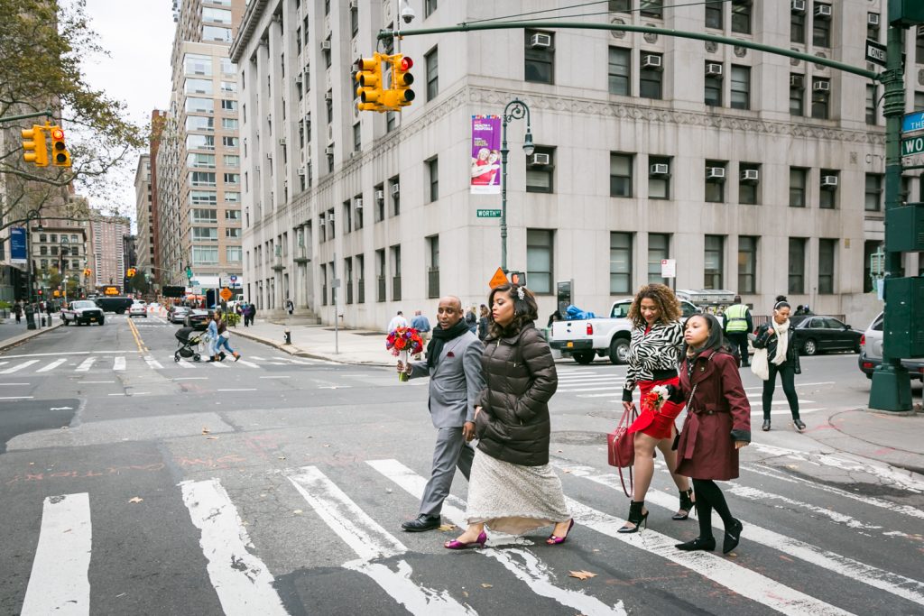 Bridal party crossing NYC street in crosswalk after City Hall wedding