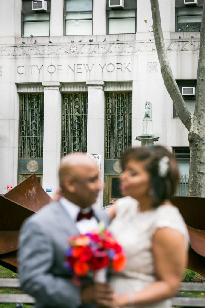 City of New York sign on building in focus in background and bride and groom out of focus in foreground