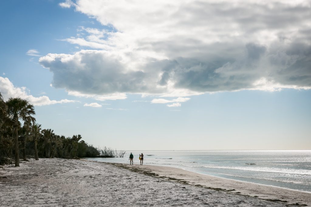 Two people walking along beach for article on Honeymoon Island photos