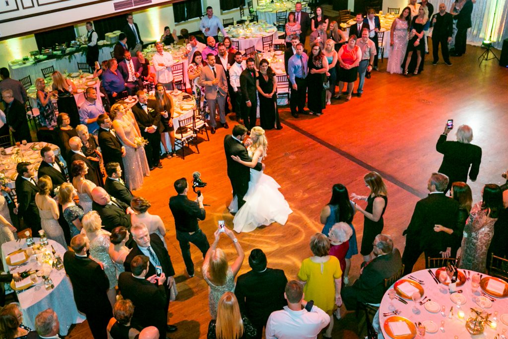 Wide shot looking down at bride and groom's first dance for an article on how DJ lighting affects your wedding photos