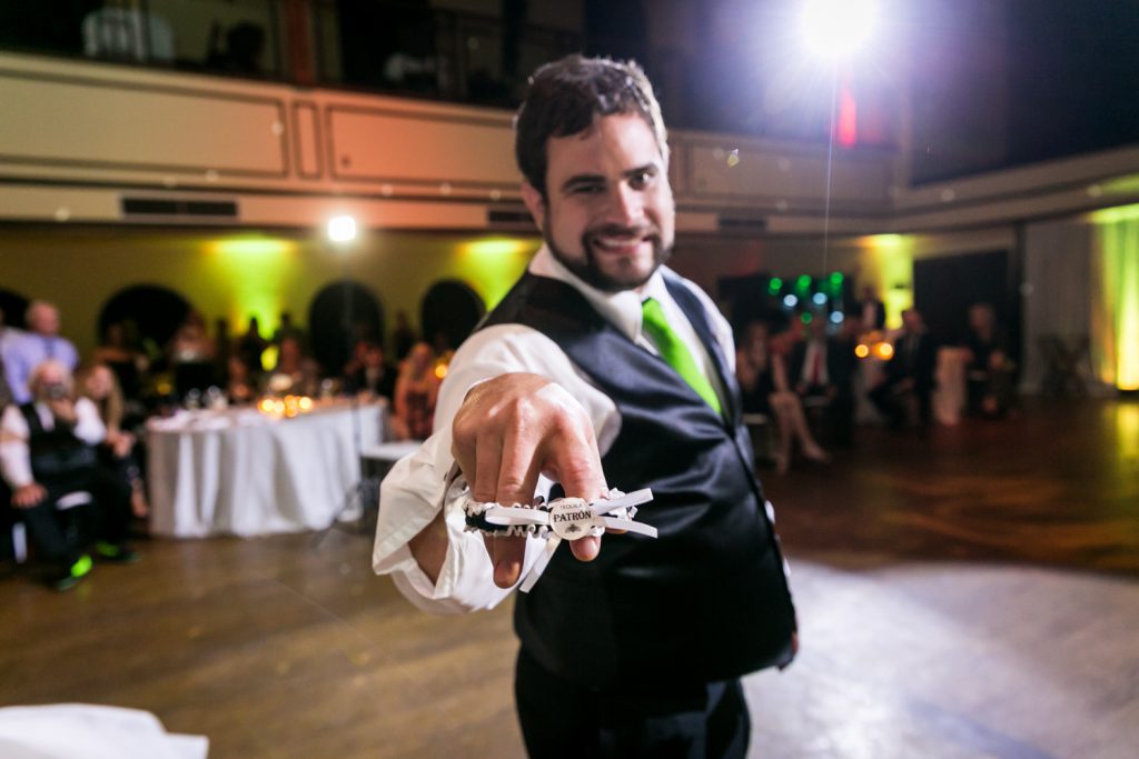 Groom showing off bride's garter belt 