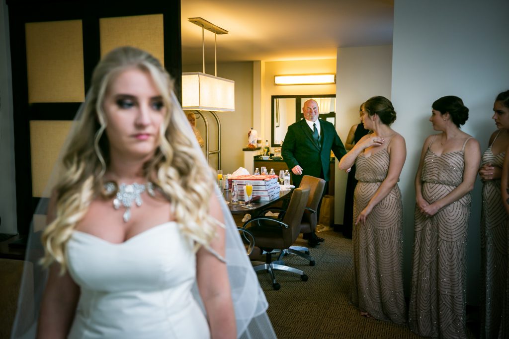 Bride turned around with father about to approach and see her dress