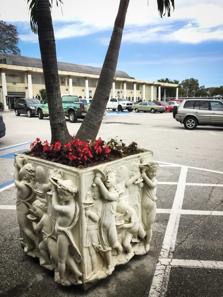 Planter with figures covering it in the parking lot of the former Kapok Tree Restaurant