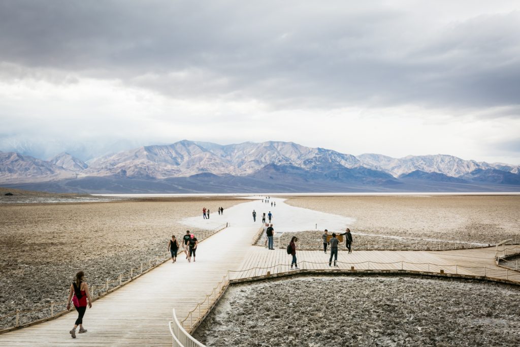 Tourists walking along boardwalk in Badwater in Death Valley National Park