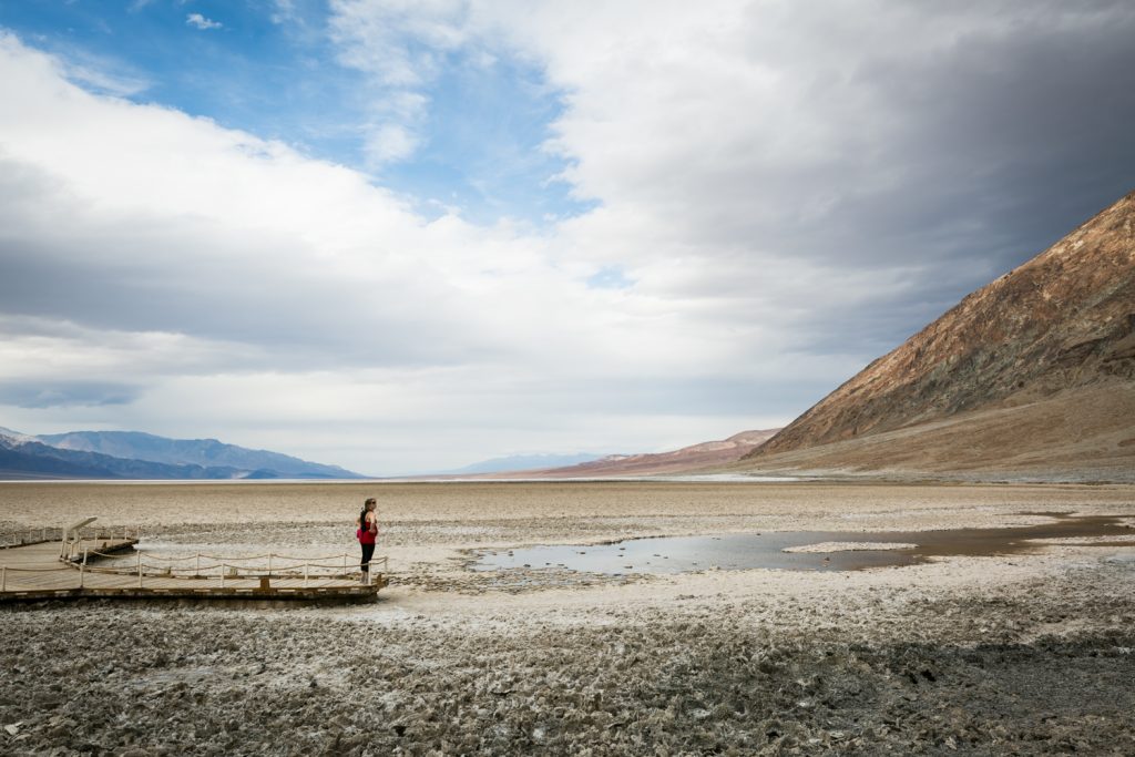 Female tourist looking at lake in Badwater in Death Valley National Park