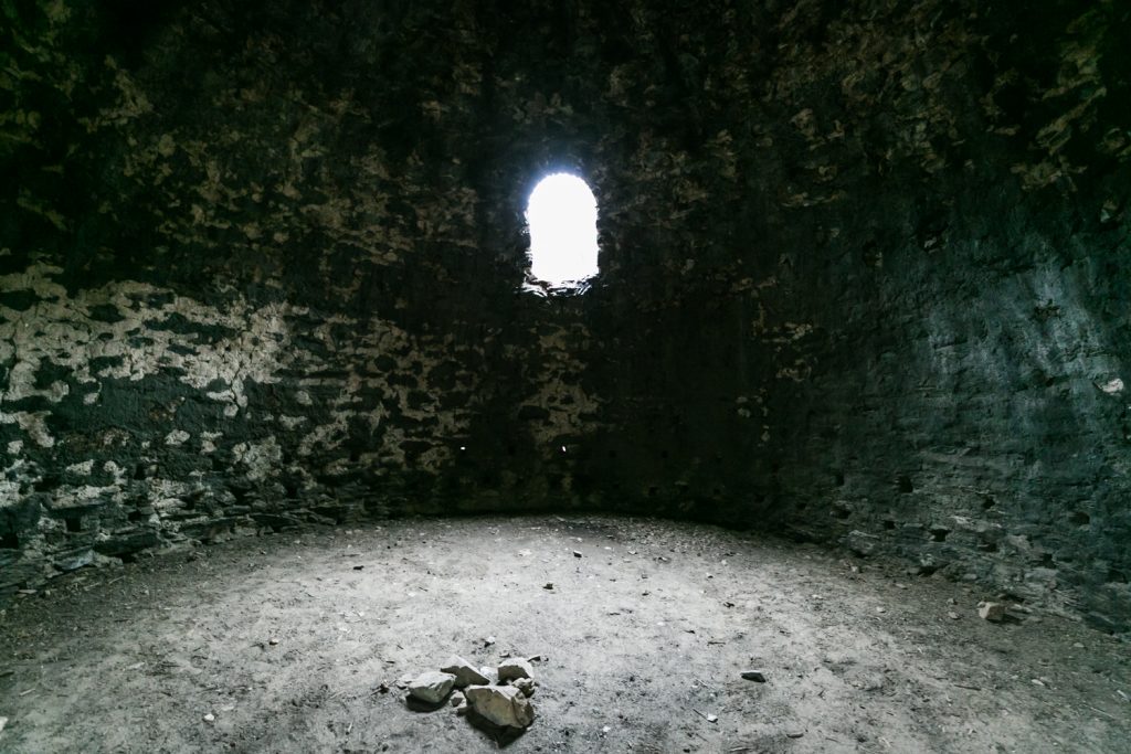 Small window shining light on rocks inside the Charcoal Kilns, Death Valley National Park