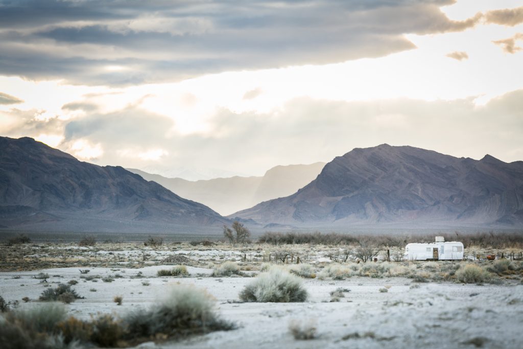Light shining through clouds with mobile home in Death Valley National Park