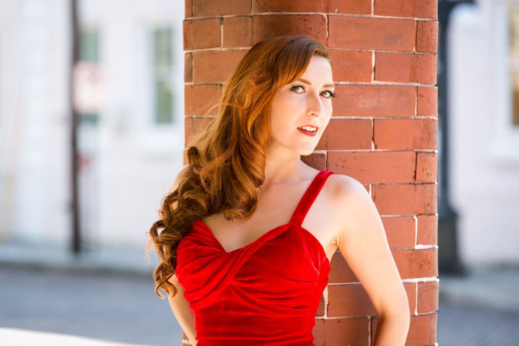Pinup model wearing red velvet dress for article about free pinup photo session offer