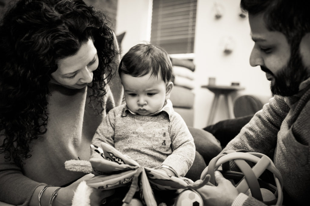 Parents reading with child for an article on indoor baby portrait tips