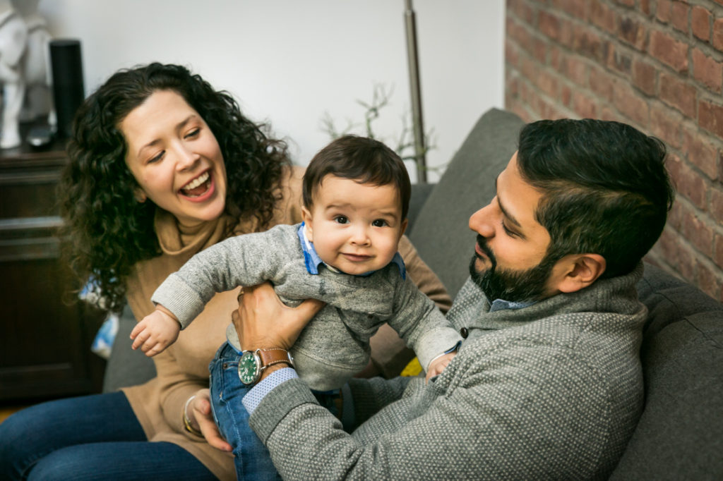 Parents playing with child for an article on indoor baby portrait tips