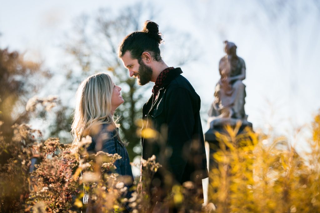 Green-Wood Cemetery engagement photos of couple behind bushes