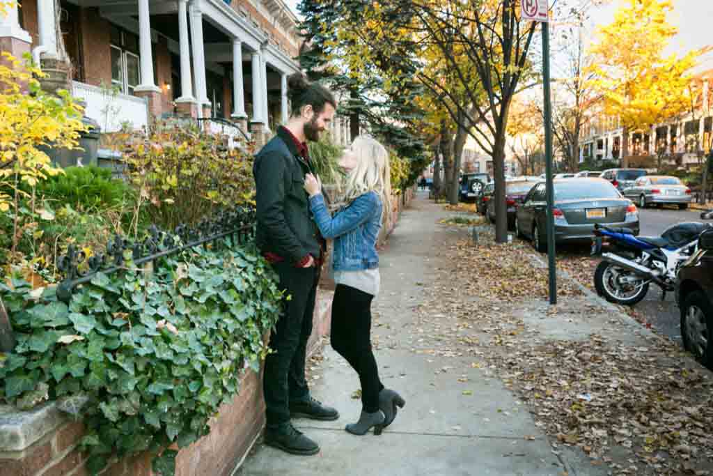 Windsor Terrace engagement photos of woman holding man by jacket on sidewalk