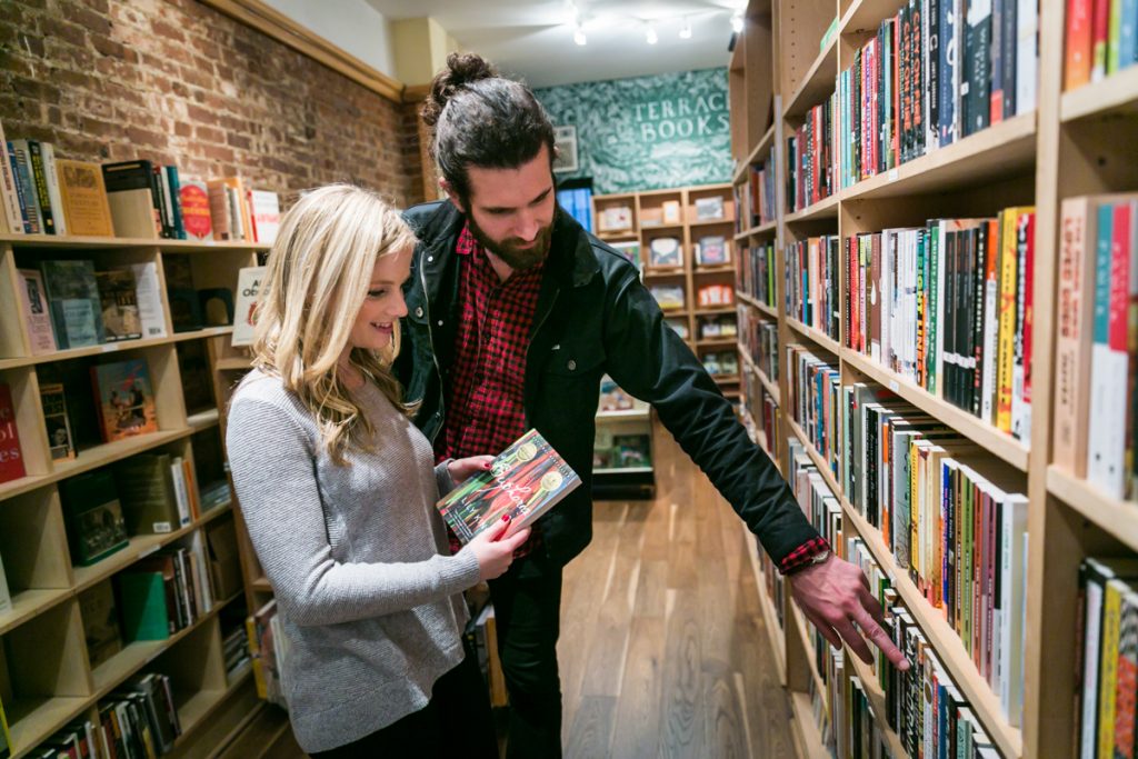 Couple in bookstore looking at books