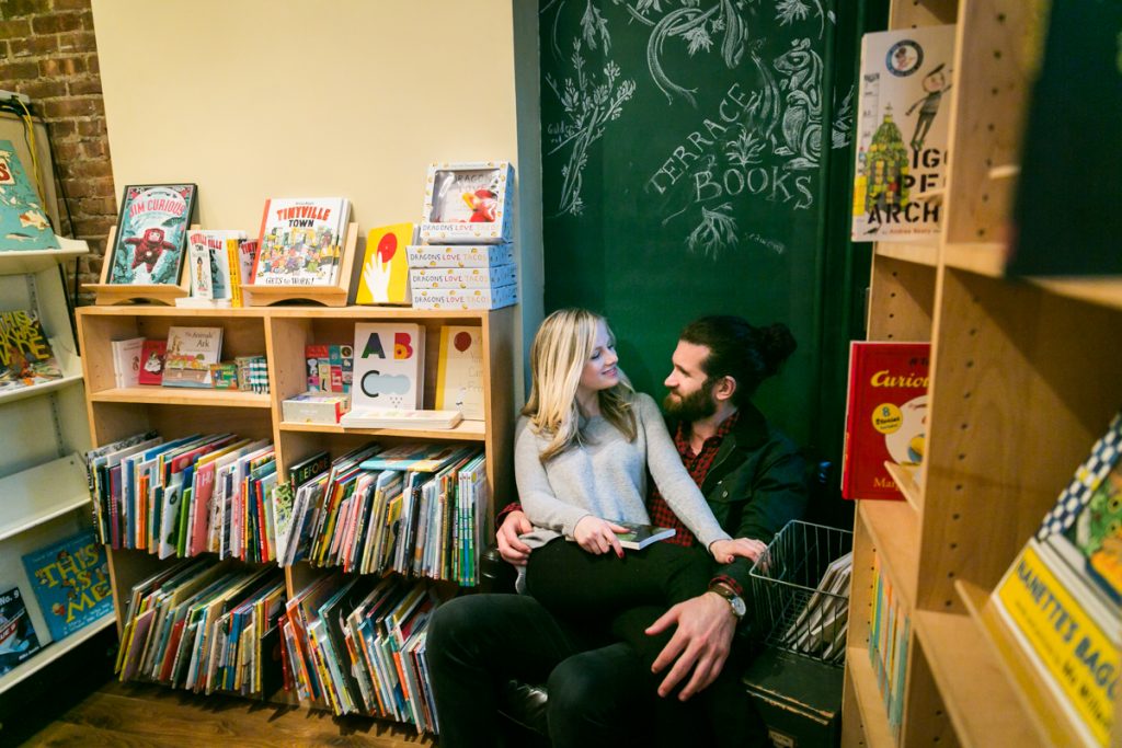 Woman sitting on man's lap in bookstore