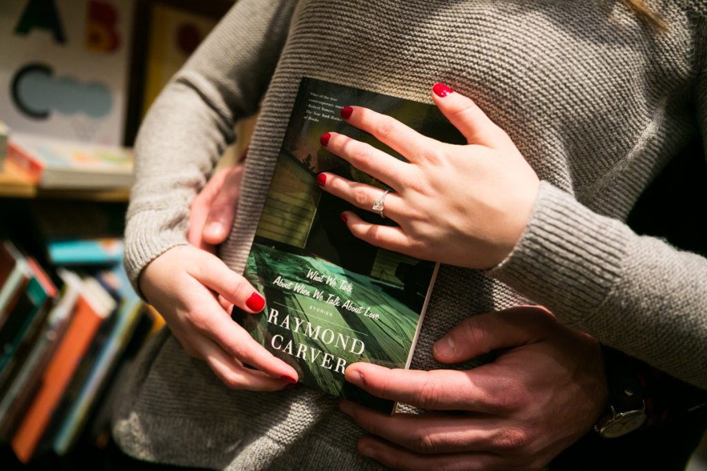 Close up of couple's hands holding books