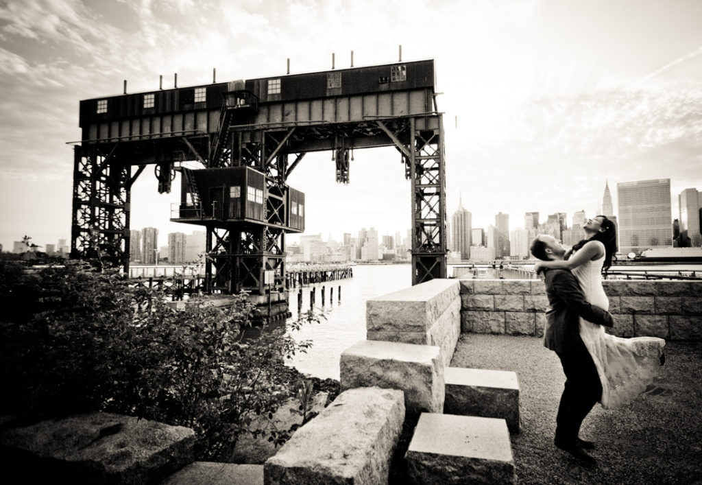 Man lifting up woman at Gantry Plaza State Park for an article on best engagement photos