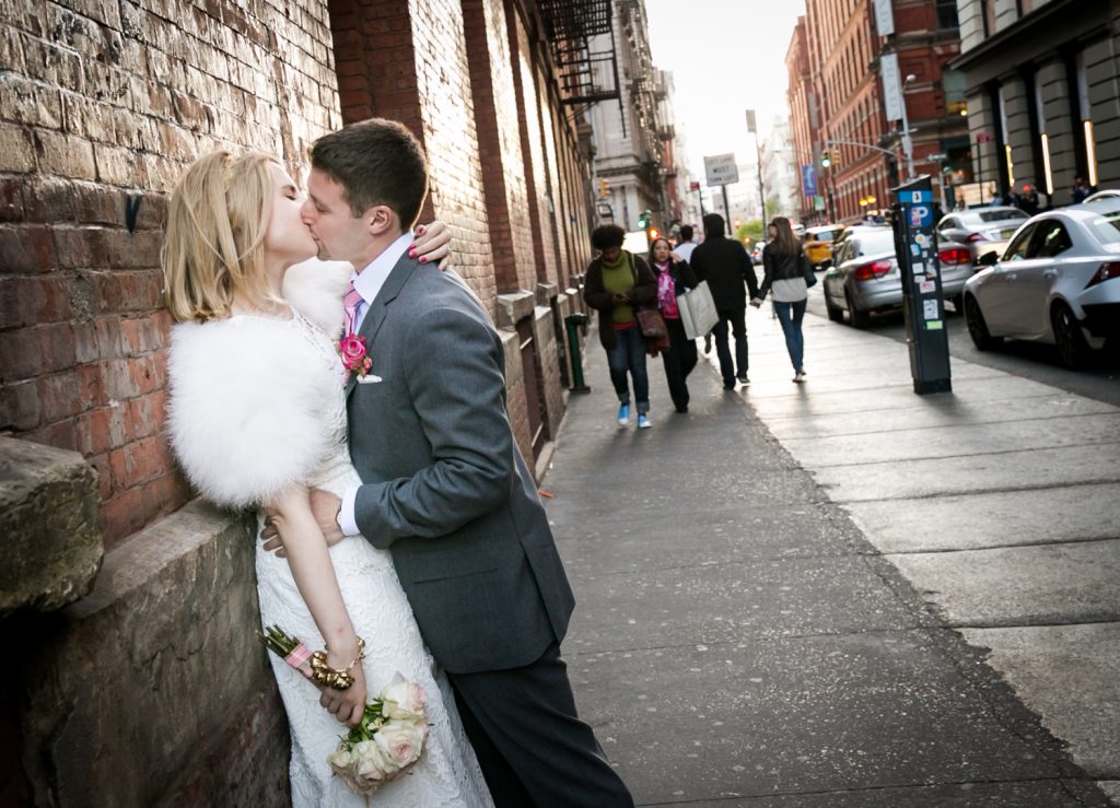 Couple kissing against wall in SoHo