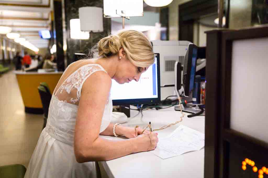 Couple signing paperwork for their NYC City Hall elopement