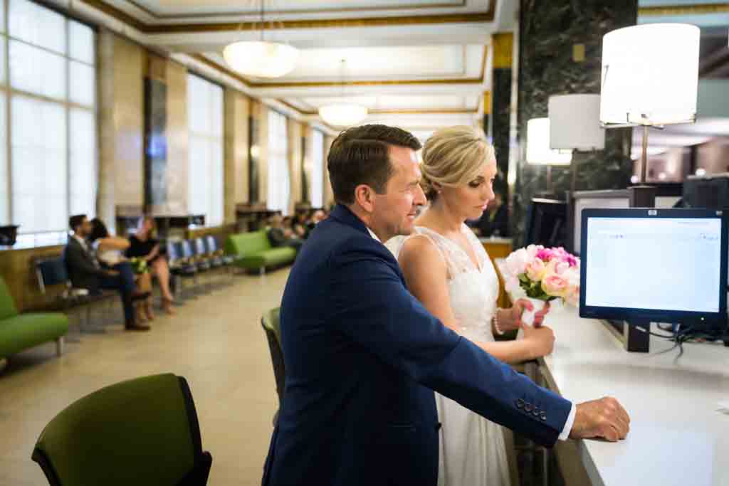 Couple signing paperwork for their NYC City Hall elopement