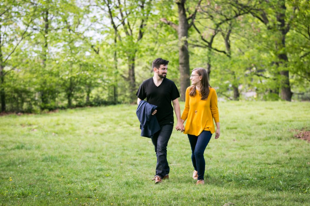 Couple walking hand-in-hand at a Fort Tryon Park engagement portrait