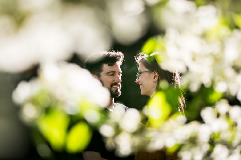 Couple through the leaves at a Fort Tryon Park engagement portrait