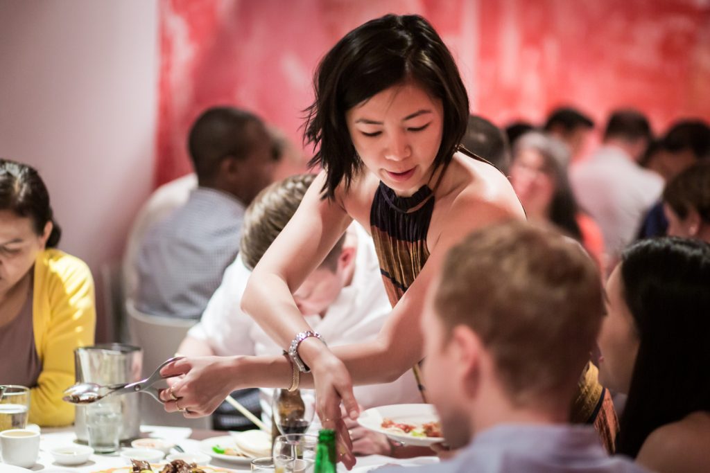Woman passing plate of food to other guests